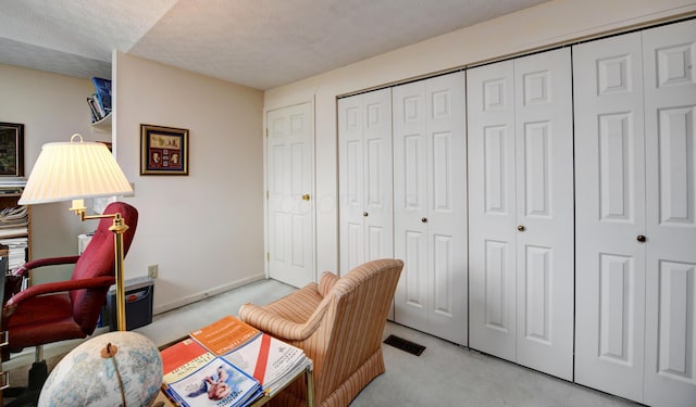 carpeted office space featuring a textured ceiling