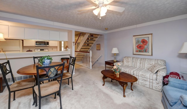 living room featuring light colored carpet, a textured ceiling, and ceiling fan