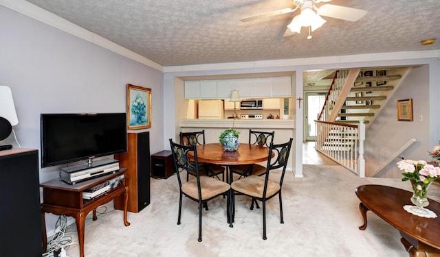 dining space featuring light colored carpet, a textured ceiling, and ceiling fan