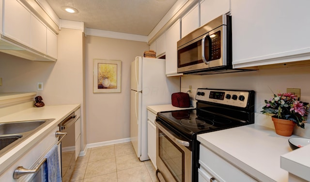kitchen with appliances with stainless steel finishes, white cabinets, light countertops, and light tile patterned floors