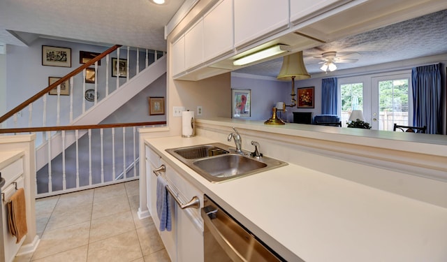 kitchen with a sink, ceiling fan, white cabinetry, light countertops, and light tile patterned floors