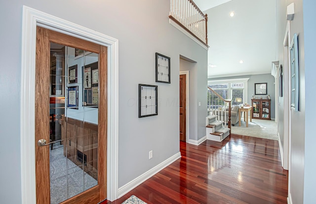 hall with wood finished floors, baseboards, and stairs