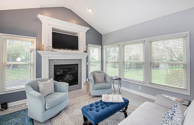 tiled living room with visible vents, baseboards, a fireplace, and lofted ceiling