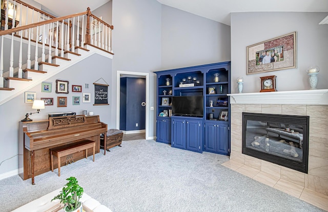carpeted living room with baseboards, high vaulted ceiling, a fireplace, and stairs