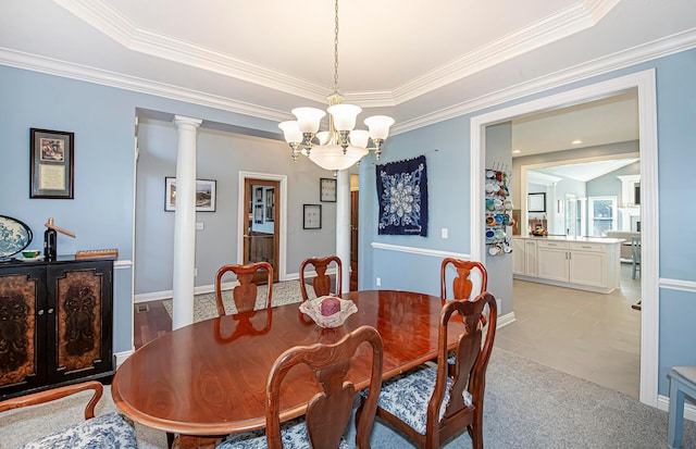 dining area featuring crown molding, a tray ceiling, baseboards, and a notable chandelier