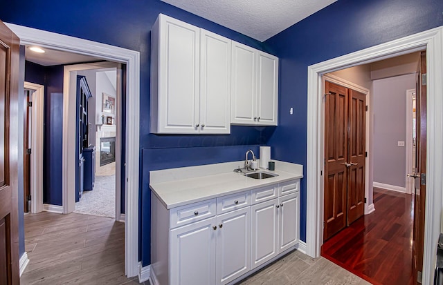 interior space featuring light wood-style floors, a sink, and baseboards