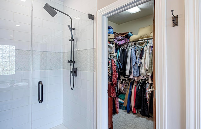 bathroom with a shower stall and a walk in closet