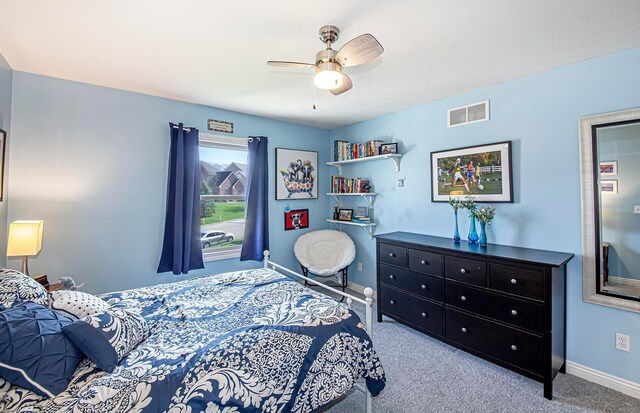 carpeted bedroom with visible vents, baseboards, and ceiling fan