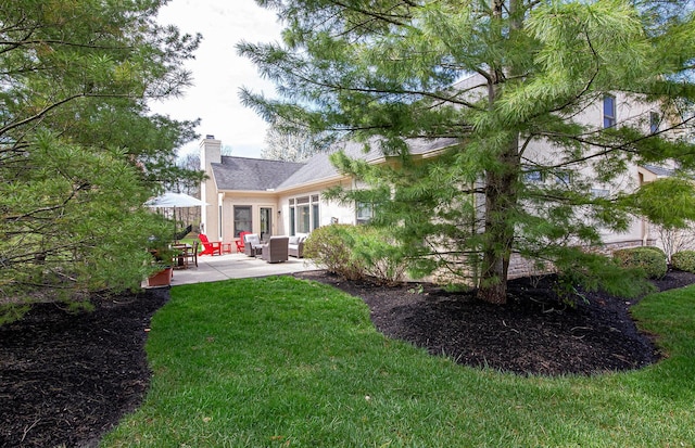 rear view of house featuring a patio area, an outdoor living space, a yard, and a chimney