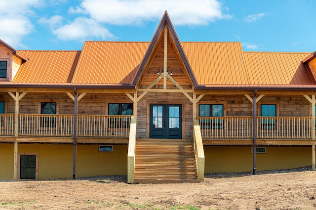 exterior space featuring french doors, metal roof, and stairs