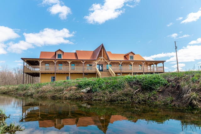 back of house with metal roof and a water view