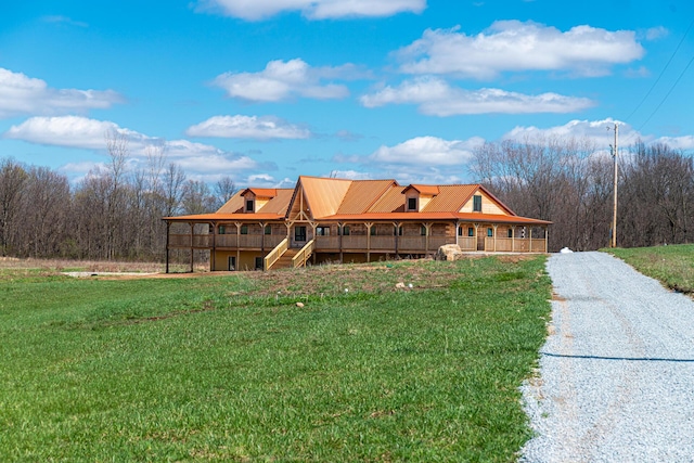 view of front of house with a front yard and a forest view