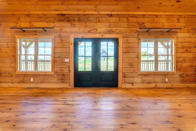 foyer featuring french doors, plenty of natural light, and hardwood / wood-style floors