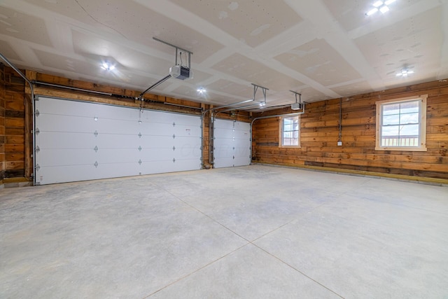 garage featuring wood walls and a garage door opener