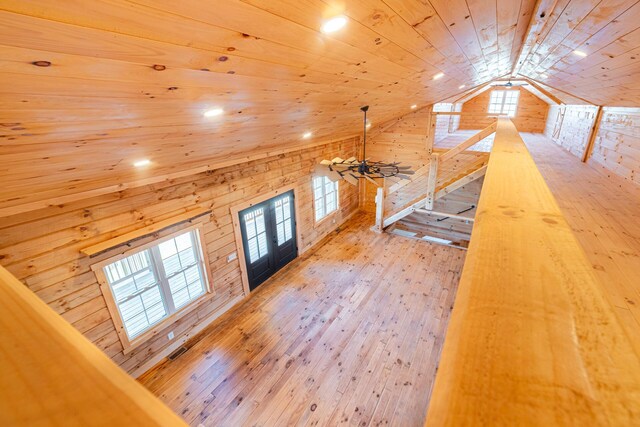 additional living space featuring wood ceiling, wooden walls, french doors, hardwood / wood-style floors, and lofted ceiling
