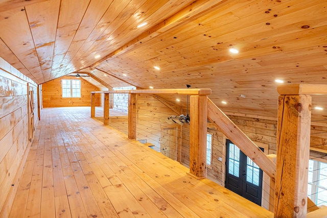 additional living space featuring wooden walls, hardwood / wood-style flooring, wood ceiling, and vaulted ceiling