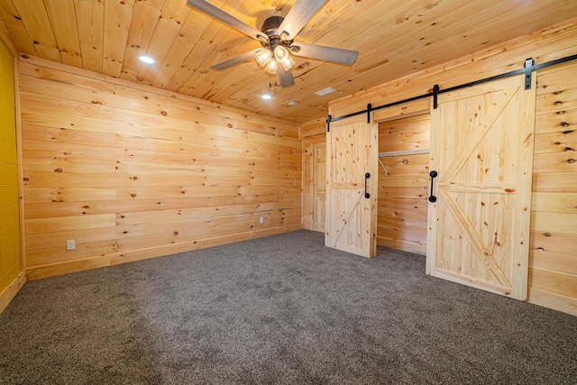 unfurnished bedroom with wood walls, a barn door, and wood ceiling
