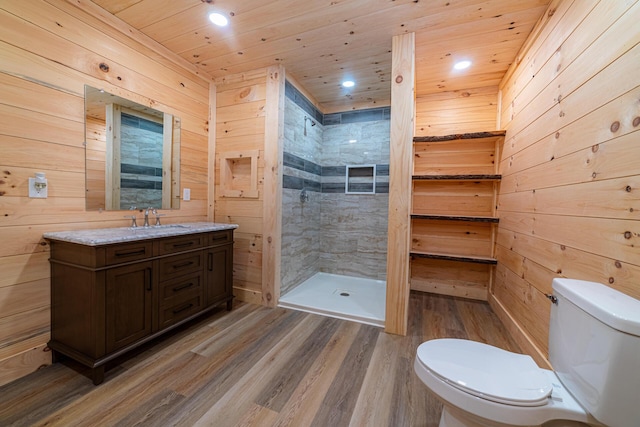 bathroom featuring wood walls, a shower stall, toilet, and wood finished floors