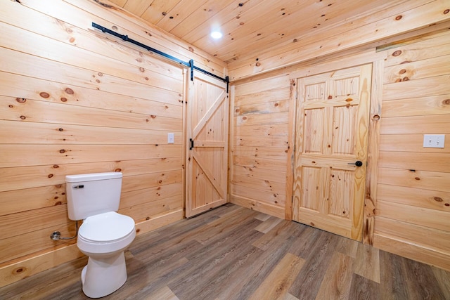bathroom featuring toilet, wood ceiling, wood finished floors, and wooden walls