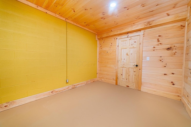 unfurnished room featuring concrete floors, wood walls, and wood ceiling