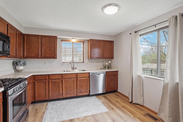 1581 Ringfield Dr, Galloway, OH 43119 - kitchen featuring light wood-style floors, a sink, visible vents, and stainless steel appliances