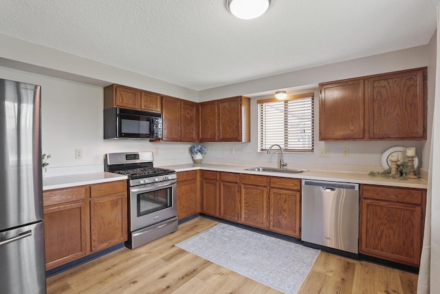 1581 Ringfield Dr, Galloway, OH 43119 - kitchen featuring a sink, light countertops, appliances with stainless steel finishes, and light wood-style floors