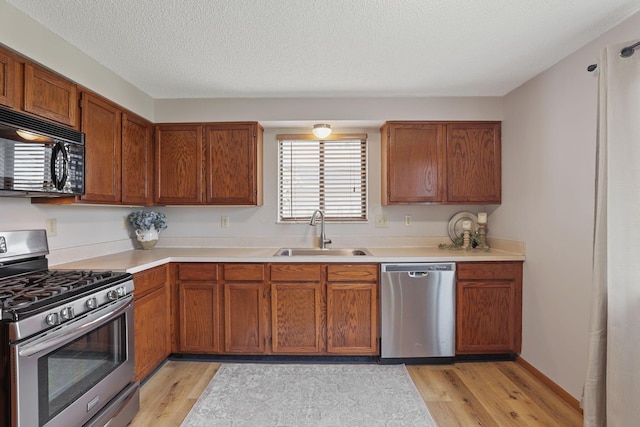1581 Ringfield Dr, Galloway, OH 43119 - kitchen with stainless steel appliances, light wood-style flooring, light countertops, and a sink