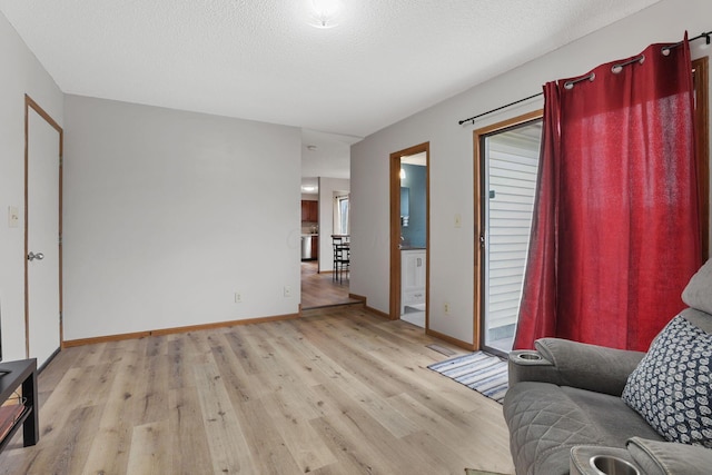 1581 Ringfield Dr, Galloway, OH 43119 - living area featuring a textured ceiling, light wood finished floors, and baseboards
