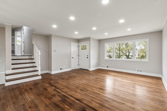 unfurnished living room featuring wood finished floors, recessed lighting, baseboards, and stairs