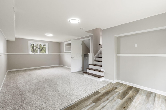 basement with stairs, baseboards, and wood finished floors