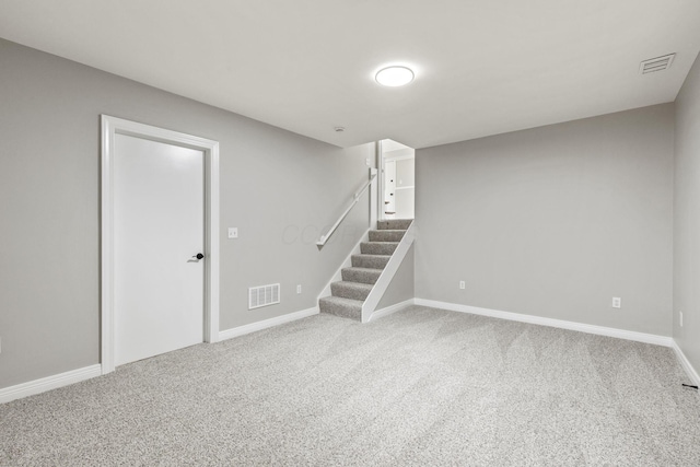 finished below grade area featuring stairway, carpet flooring, and baseboards