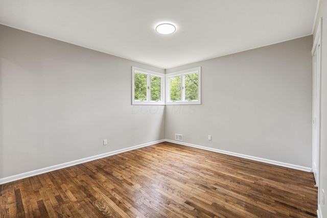 empty room featuring wood finished floors and baseboards