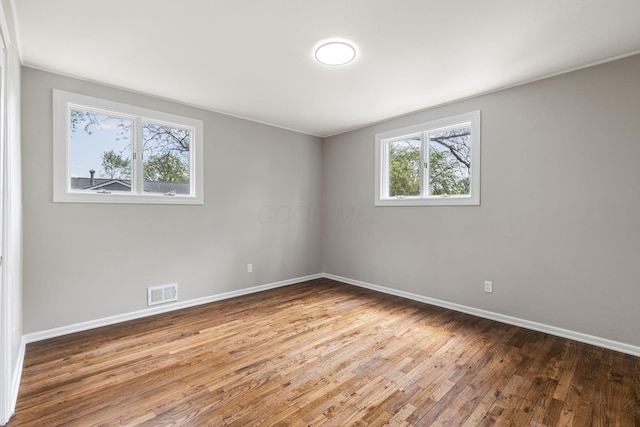 unfurnished room with baseboards and wood finished floors