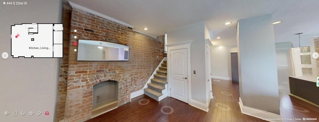 444 S 22nd St, Columbus, OH 43205 - unfurnished living room with wood finished floors, stairway, baseboards, brick wall, and a textured ceiling