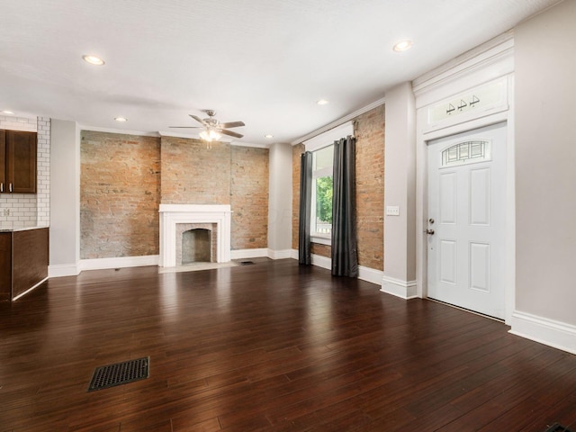 444 S 22nd St, Columbus, OH 43205 - unfurnished living room featuring a fireplace with flush hearth, ceiling fan, brick wall, wood finished floors, and baseboards
