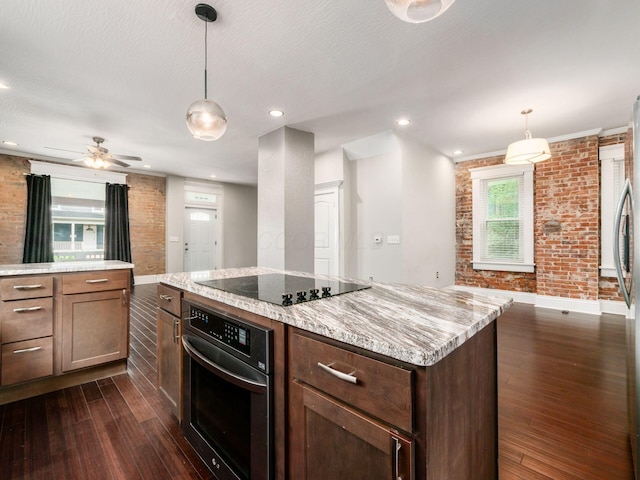 444 S 22nd St, Columbus, OH 43205 - kitchen featuring oven, black electric cooktop, brick wall, dark wood-style floors, and baseboards
