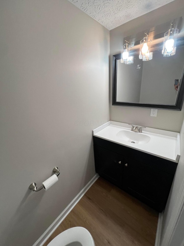 796 Village Park Dr, Powell, OH 43065 - half bathroom featuring vanity, baseboards, a textured ceiling, toilet, and wood finished floors