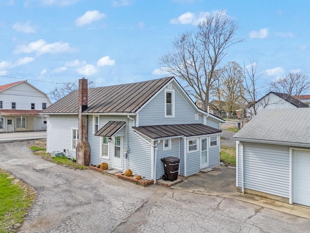 exterior space with entry steps, a chimney, a standing seam roof, and metal roof