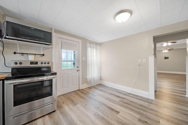 kitchen with baseboards, light wood finished floors, stainless steel electric range oven, and a ceiling fan