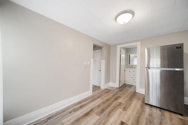 interior space with a sink, baseboards, and wood finished floors