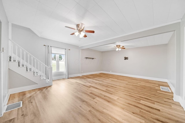 unfurnished living room featuring stairway, visible vents, light wood-style flooring, and ceiling fan