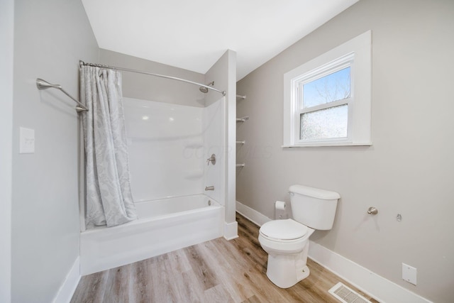 bathroom with toilet, wood finished floors, baseboards, and visible vents
