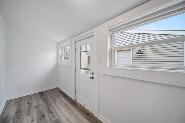 entryway with baseboards, vaulted ceiling, and wood finished floors