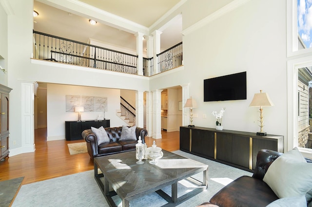 6795 Macneil Dr, Dublin, OH 43017 - living area featuring baseboards, decorative columns, wood finished floors, and stairs