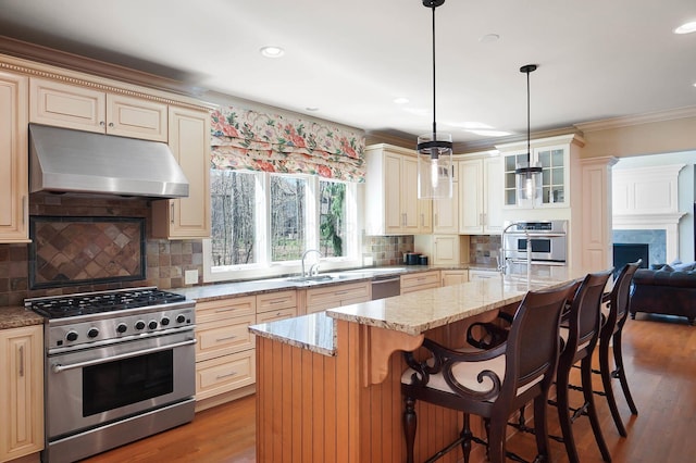 6795 Macneil Dr, Dublin, OH 43017 - kitchen with crown molding, cream cabinetry, under cabinet range hood, stainless steel appliances, and a sink