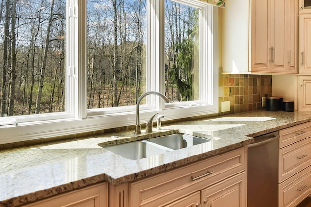 6795 Macneil Dr, Dublin, OH 43017 - kitchen featuring decorative backsplash, light stone counters, dishwasher, and a sink