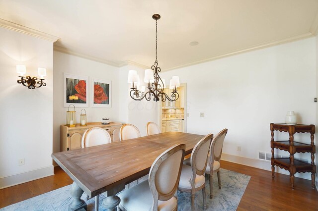 6795 Macneil Dr, Dublin, OH 43017 - dining room with a chandelier, baseboards, ornamental molding, and dark wood finished floors