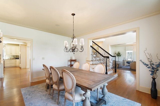 6795 Macneil Dr, Dublin, OH 43017 - dining space with baseboards, an inviting chandelier, ornamental molding, light wood-style flooring, and stairs
