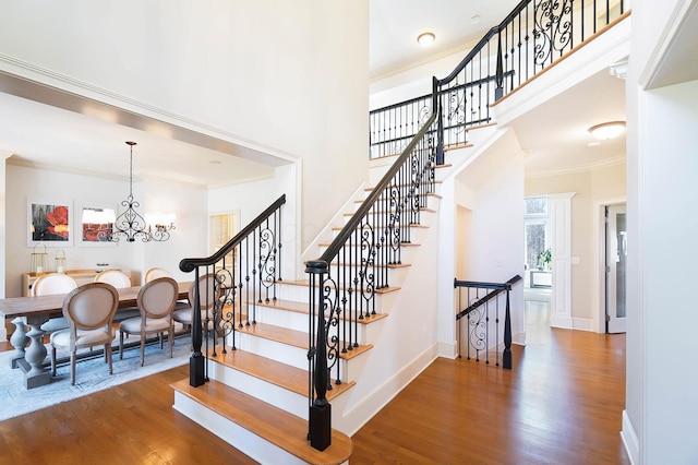 6795 Macneil Dr, Dublin, OH 43017 - staircase with ornamental molding, a towering ceiling, wood finished floors, and a healthy amount of sunlight