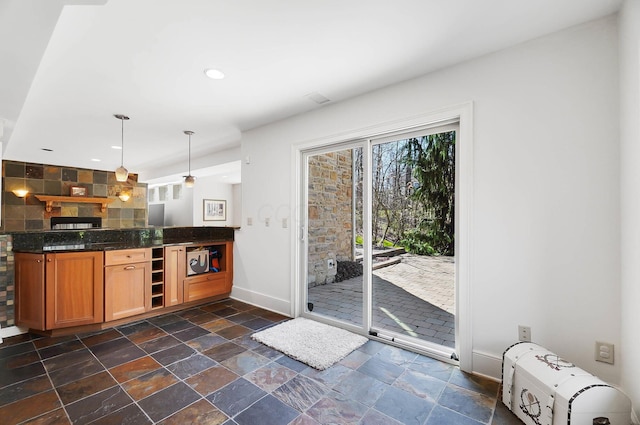 6795 Macneil Dr, Dublin, OH 43017 - kitchen with pendant lighting, stone tile floors, recessed lighting, brown cabinets, and baseboards